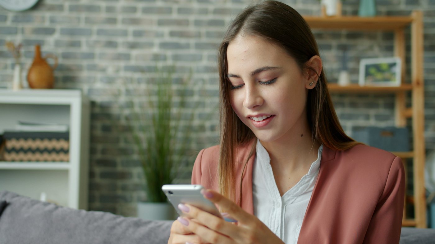 Woman on her couch looking at her phone