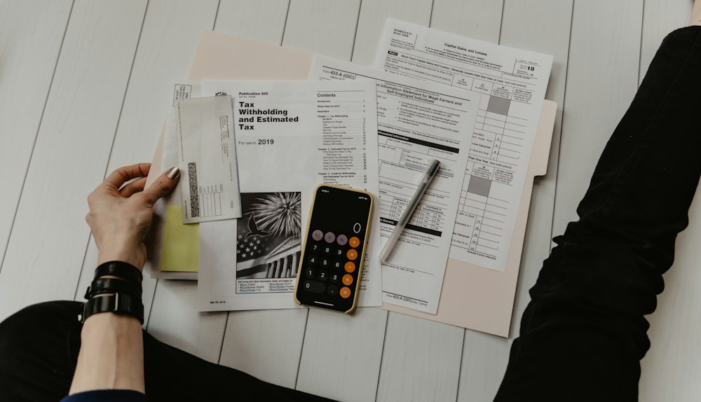 Tax forms, a calculator and a pen on a desk